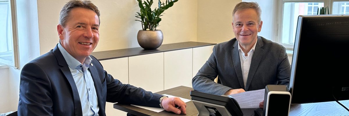 Bürgermeister Erwin Angerer und Doktor Alberere sitzen an einem Bürotisch zusammen